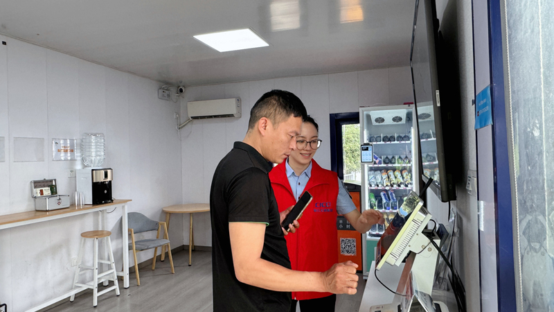 纳凉亭内宁波收费站工作人员帮助司乘打印发票。浙江交通集团供图
