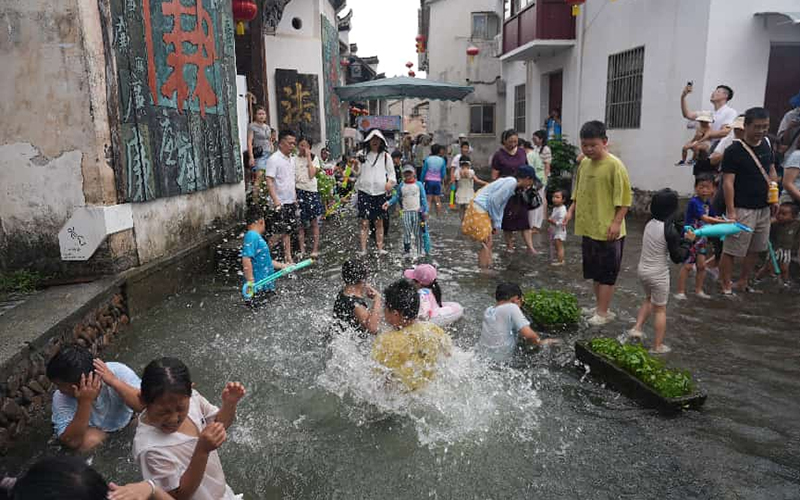 游客在注满山泉水的老街上嬉戏。桐庐县委宣传部供图