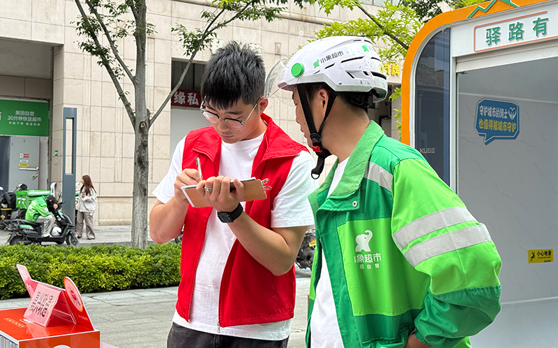 社区工作者收集骑手意见建议。秀洲区委宣传部供图