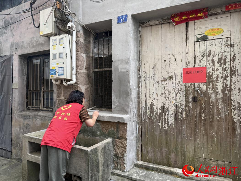 王银玉查看搬空房屋是否有折返人员。人民网记者 方彭依梦摄