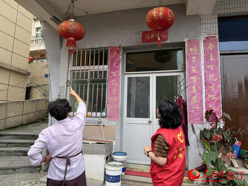 王银玉提醒居民将灯笼取下、杂物收好。人民网记者 方彭依梦摄