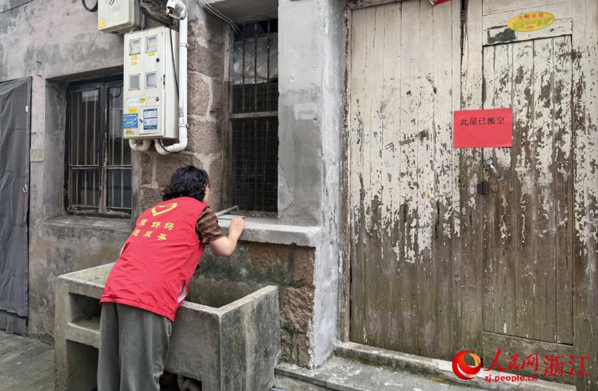 王银玉查看搬空房屋是否有折返人员。人民网记者 方彭依梦摄