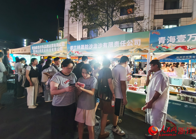 摊位前，游客了解海西州枸杞。人民网 刘欣蔚摄