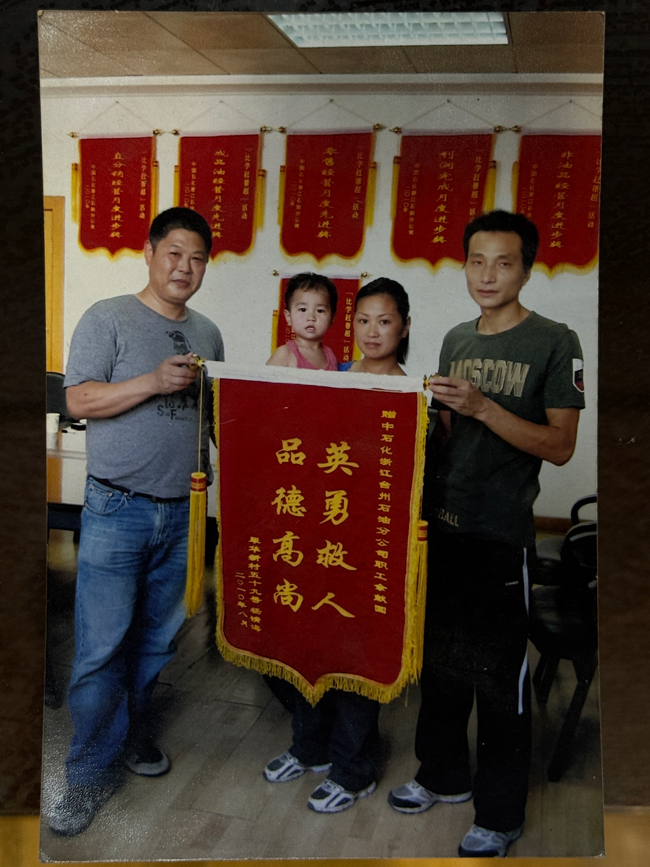 2010年，郑妍一家给余献国（左一）送锦旗。受访者供图