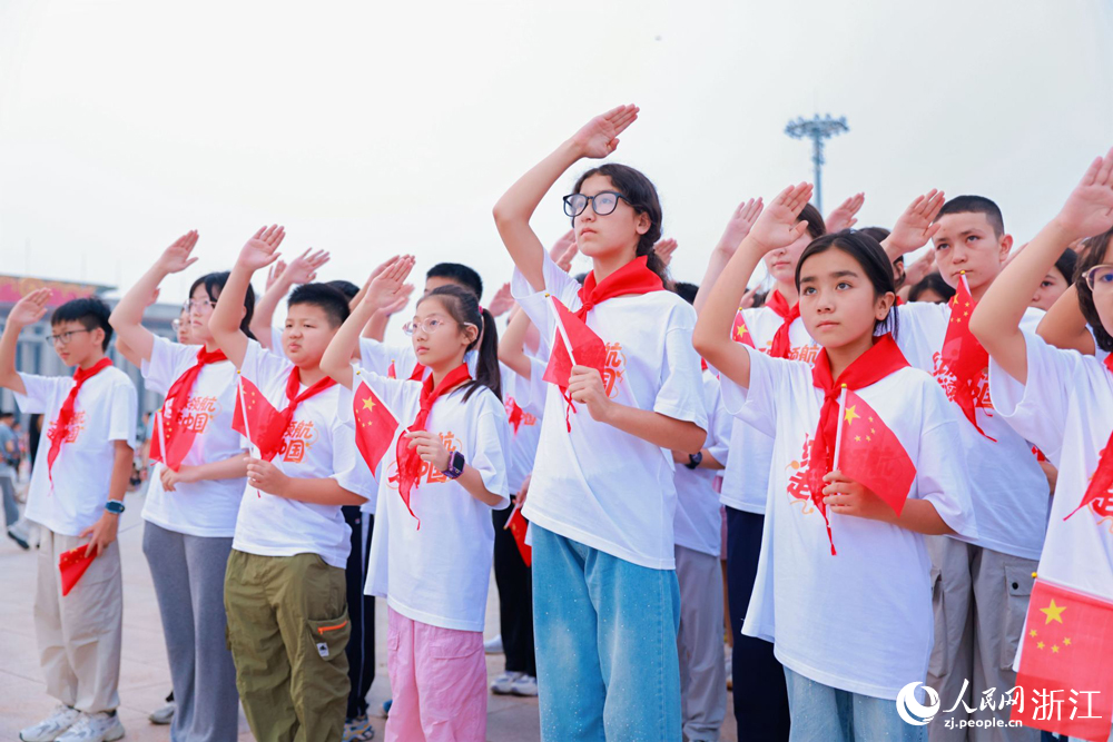 来自新疆阿克苏与浙江杭州的学子们一同观看升旗仪式。人民网 刘欣蔚摄