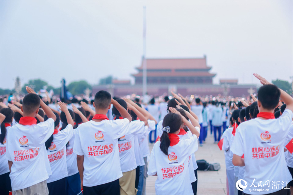 来自新疆阿克苏与浙江杭州的学子们一同观看升旗仪式。人民网 刘欣蔚摄