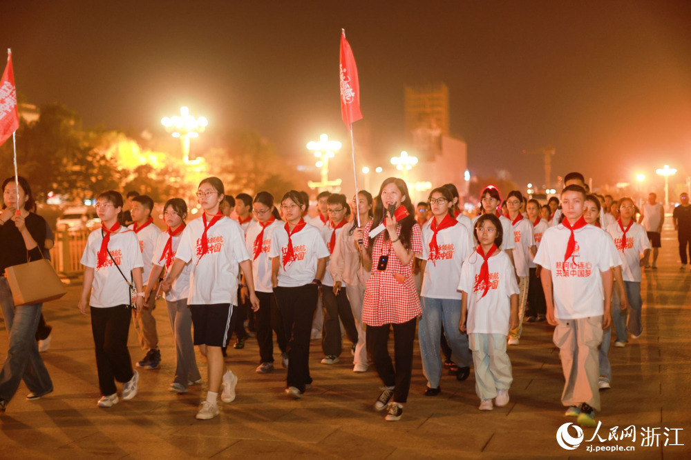来自新疆阿克苏与浙江杭州的学子们一同观看升旗仪式。人民网 程欣摄