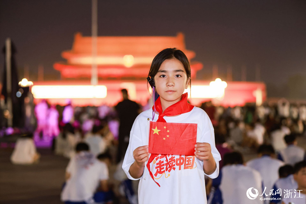 来自新疆阿克苏与浙江杭州的学子们一同观看升旗仪式。人民网 程欣摄