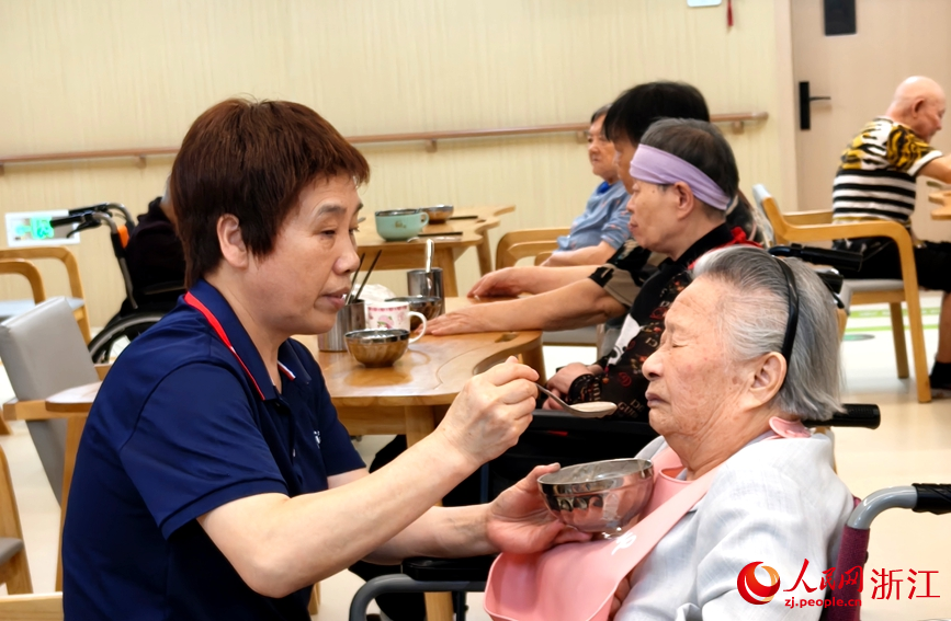 护工帮助老人就餐。人民网记者 张丽玮摄