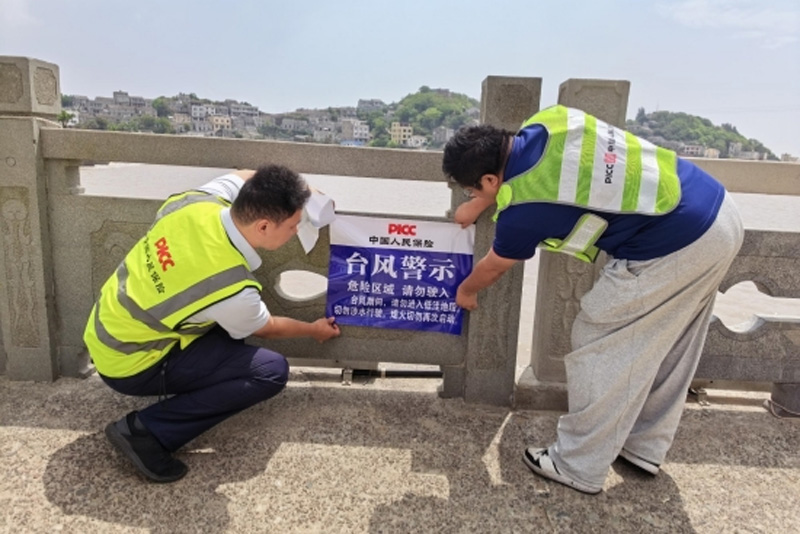 人保财险员工张贴防台警示,切实保障人民群众生命财产安全。浙江人保财险供图