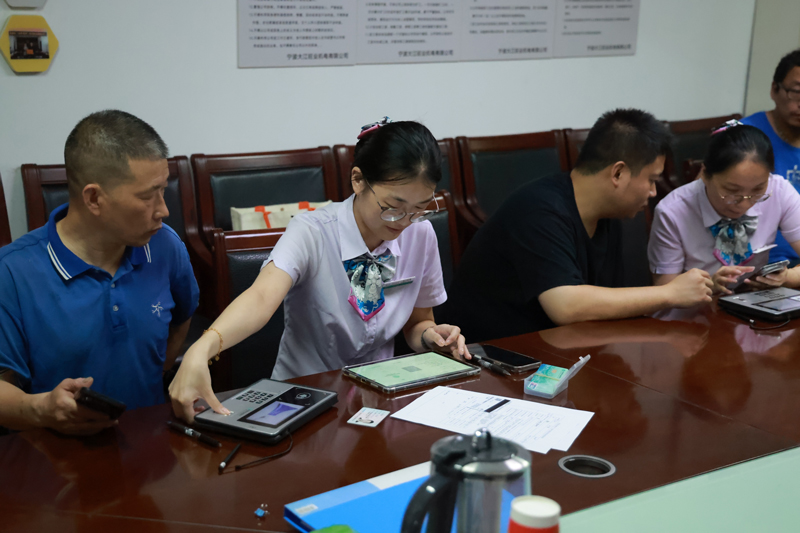 农行工作人员为宁波大江旺业五金机电有限公司员工提供一站式上门开卡服务。赵璐摄
