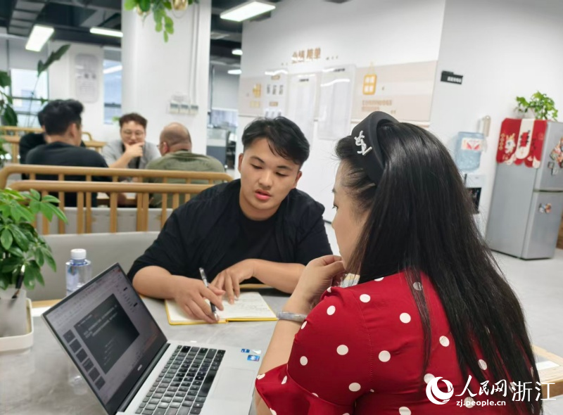 大学生企业高管助理赵温杰与何佳波正讨论工作。人民网记者 康梦琦摄