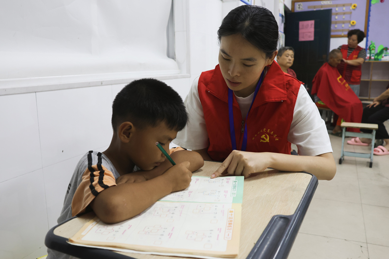 安置點內,志願者教小孩子做題。路南街道供圖