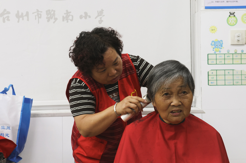 安置點內,於偉紅正忙著給老人義剪。路南街道供圖
