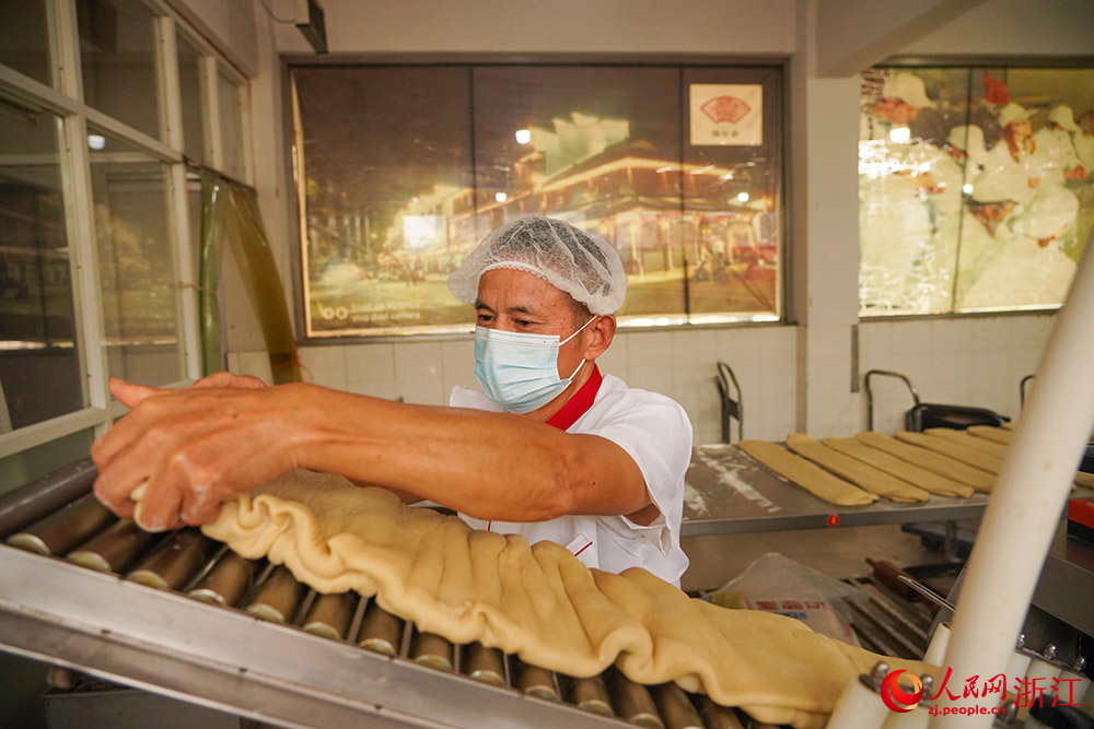 在浙江省嘉兴市秀洲区新塍镇，糕饼作坊内工人正加紧赶制月饼订单。人民网 章勇涛摄