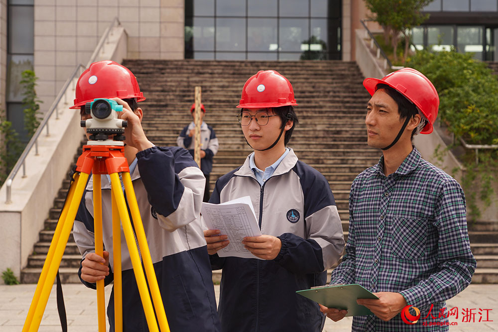 在宁波市宁海县第一职业中学，学生在室外进行四等水准测量外业观测实操练习。人民网 章勇涛摄