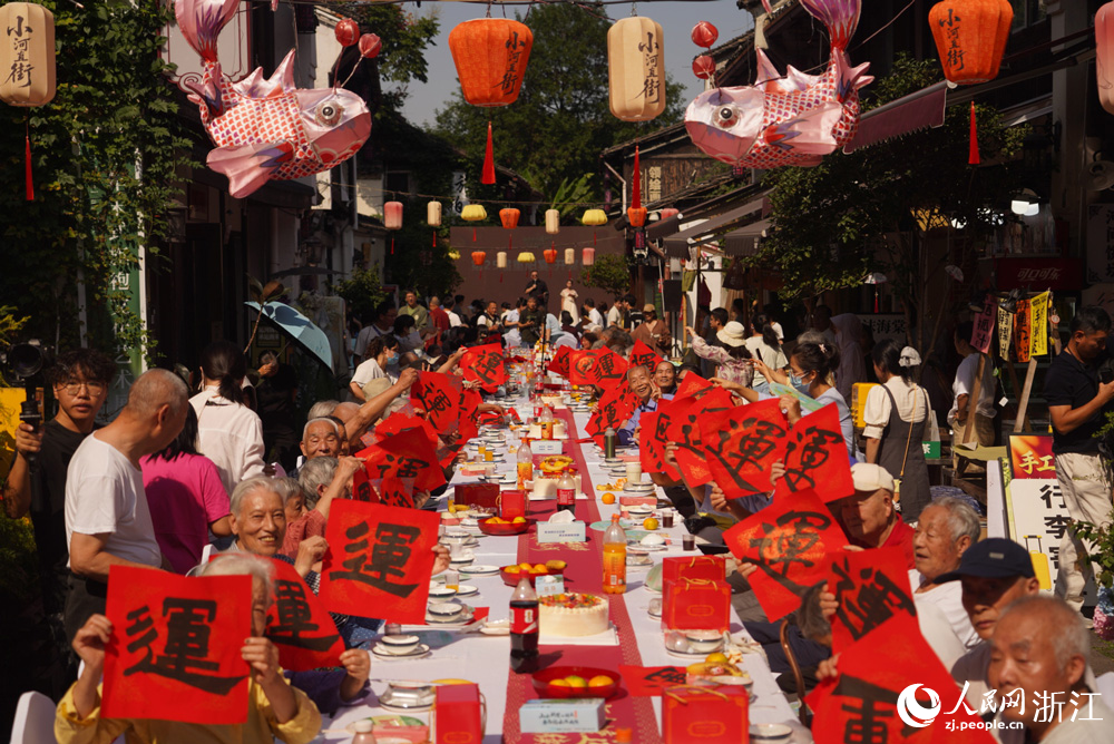 10月18日，杭州市拱墅區小河街道第二十五屆重陽長桌宴在小河直街開席，百名長者歡聚一堂，共慶重陽。人民網 章勇濤攝