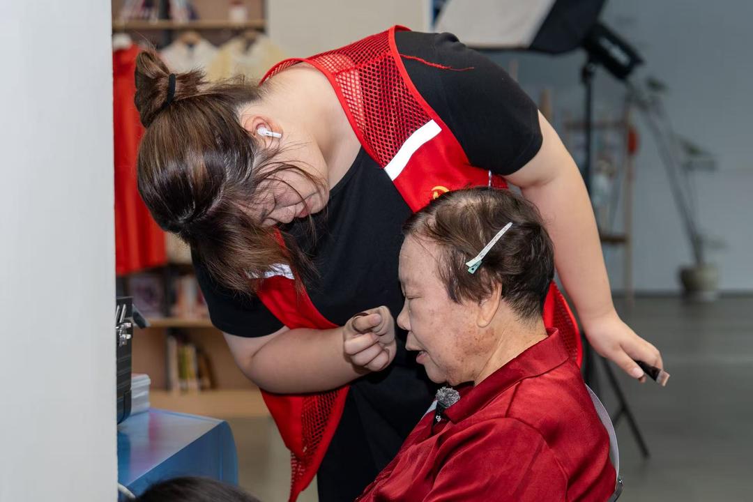 志願者正在為老人化妝。孫帥琦攝