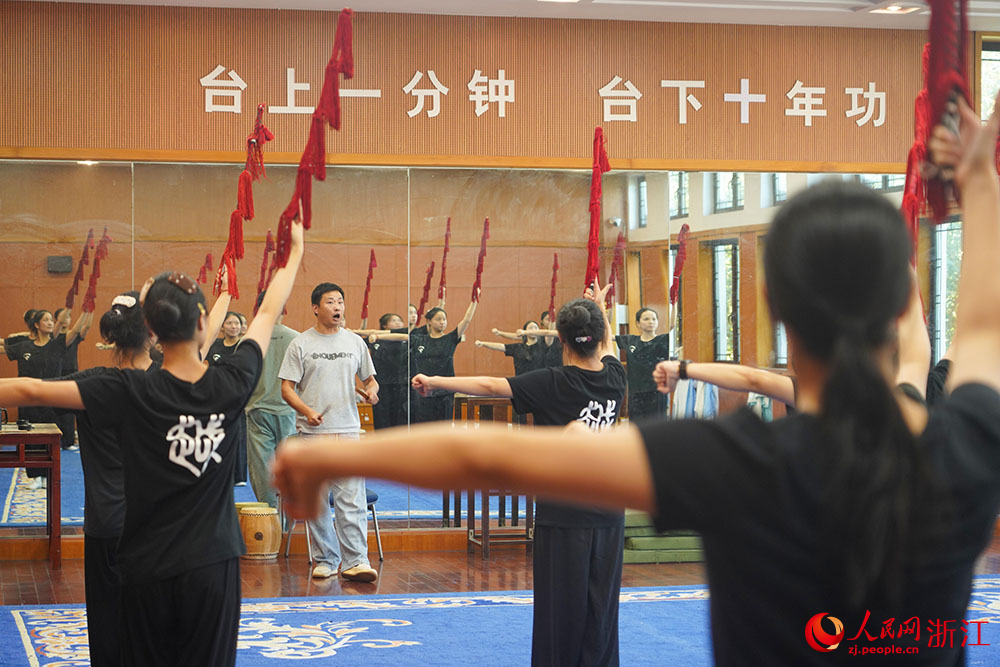 在浙江嵊州越剧艺术学校内，老师带领学生们正在练习唱腔身段，一招一式打磨戏曲基本功。人民网 章勇涛摄