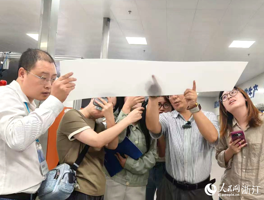 工作人员（左二）讲解量子扩散板优势。人民网记者 张丽玮摄