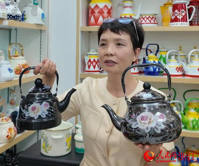 劉俊英展示自己設計生產的黑色鏡面釉搪瓷壺。人民網記者 孫鵬攝