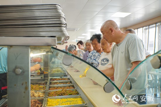 恒通社区老年食堂内，老人们正在排队打菜。人民网 陈若天摄