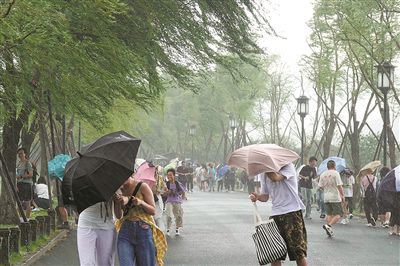昨天下午2点左右，西湖上空飘来一团乌云，瞬时狂风大作、暴雨倾盆，令白堤上众多无处藏身的游客措手不及。记者 李忠 摄